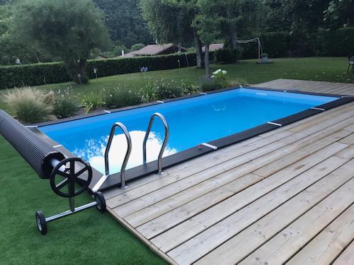 Photograph of an inground pool in a garden with a wooden deck