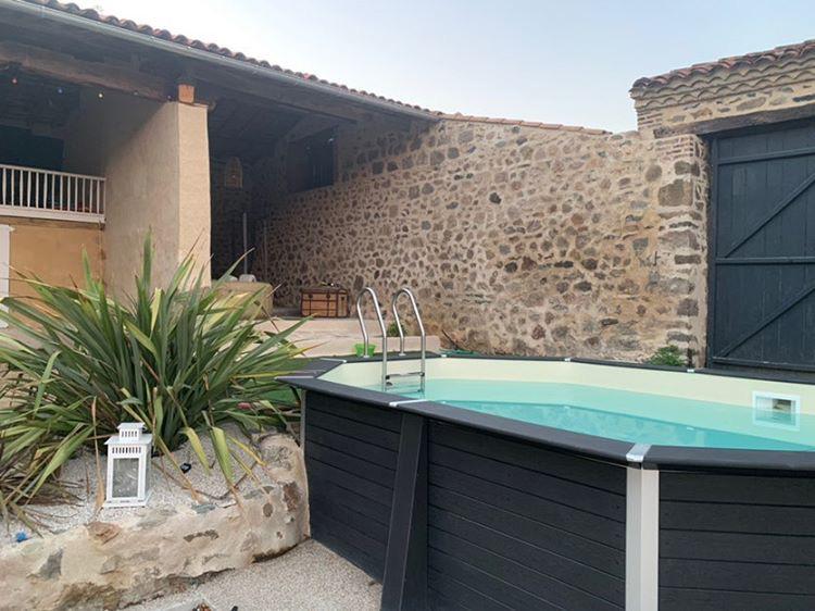 Above ground hexagonal pool with a stone wall