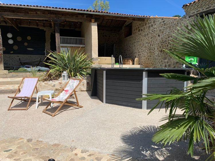 Black hexagonal pool side view with two lounge chairs