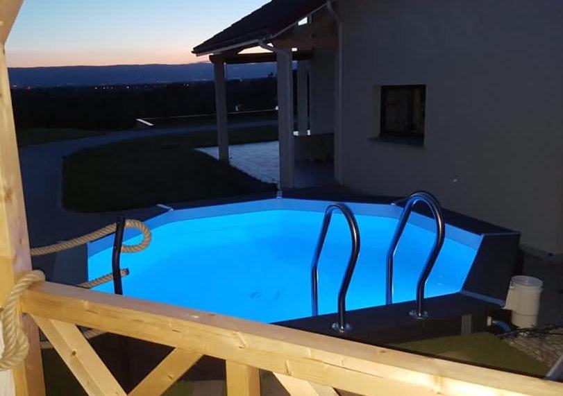 Black hexagonal above ground pool illuminated in blue at night