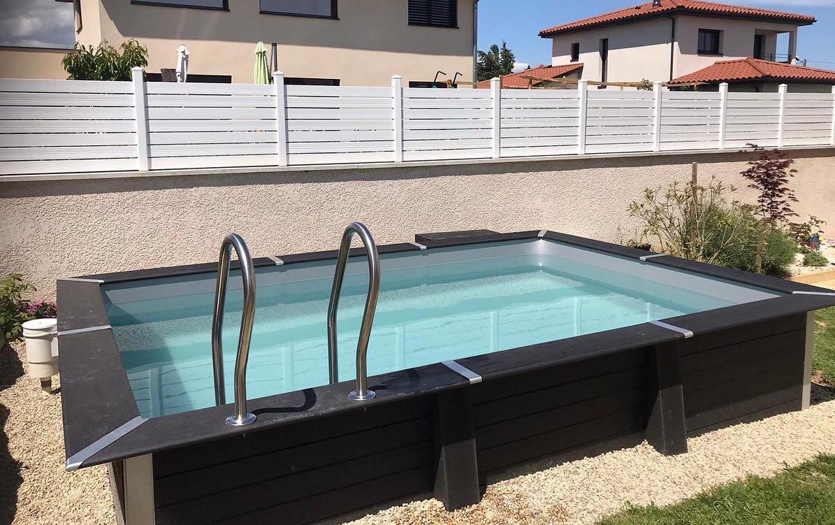 Small black rectangular pool seen from the side in front of a wall